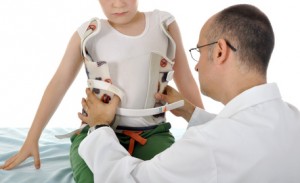 Arzt behandelt Kind mit Stützkorsett